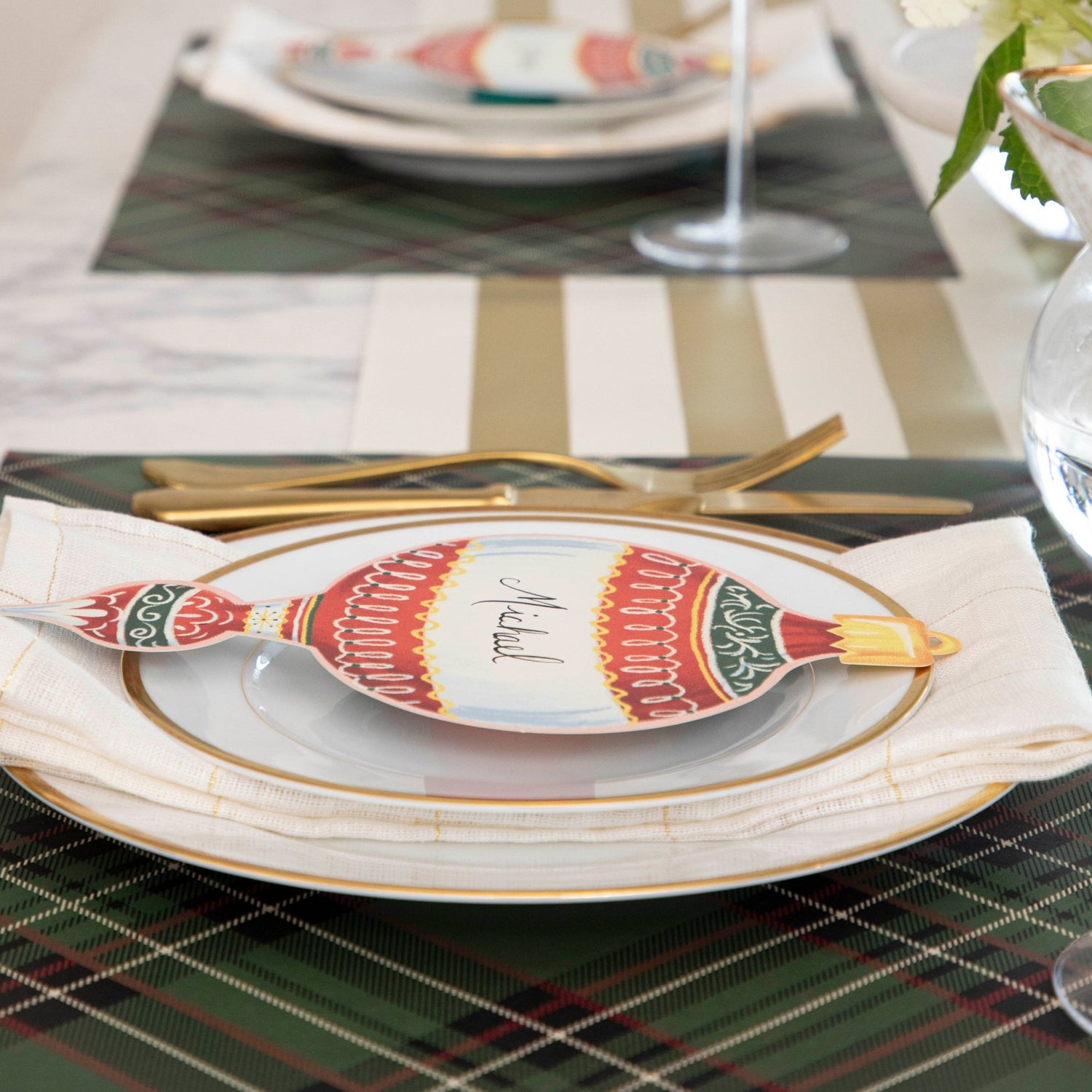 Close-up of the Green Plaid Placemat under a festive holiday-themed table setting.