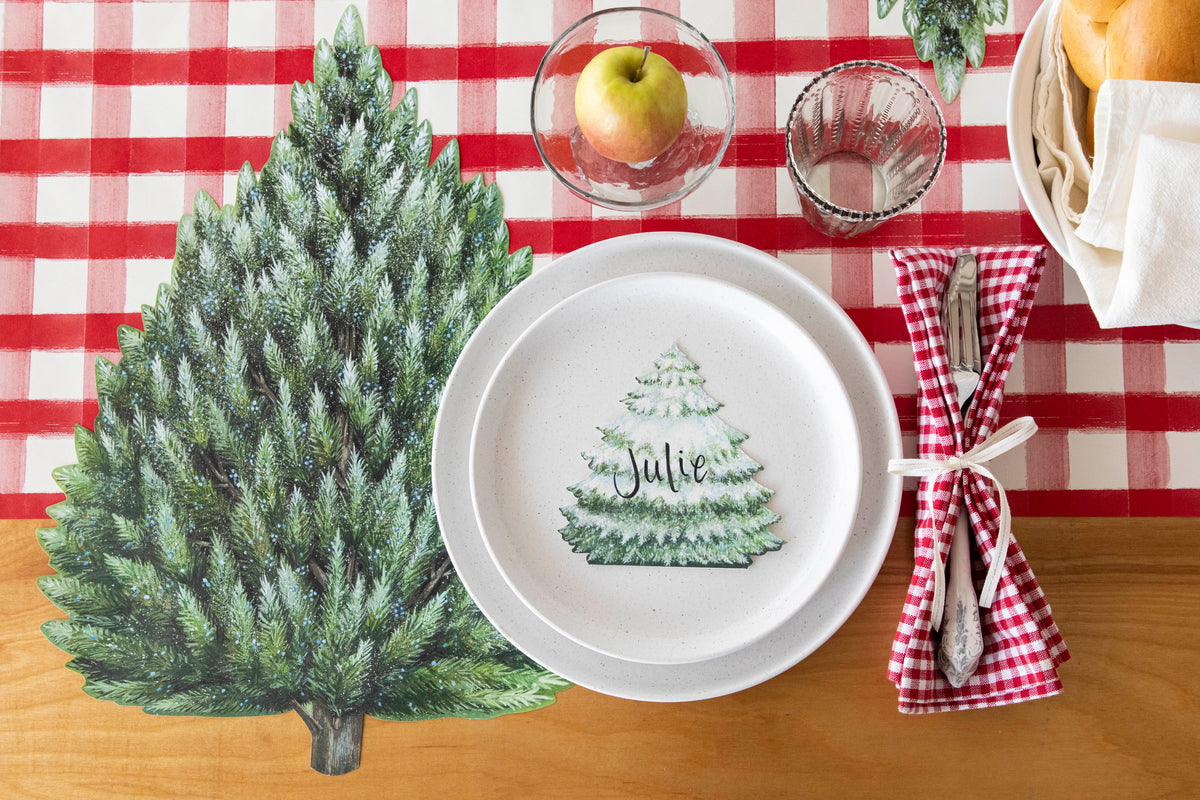 Top-down view of a rustic place setting featuring an Evergreen Place Card labeled "Julie" laying flat on the plate.