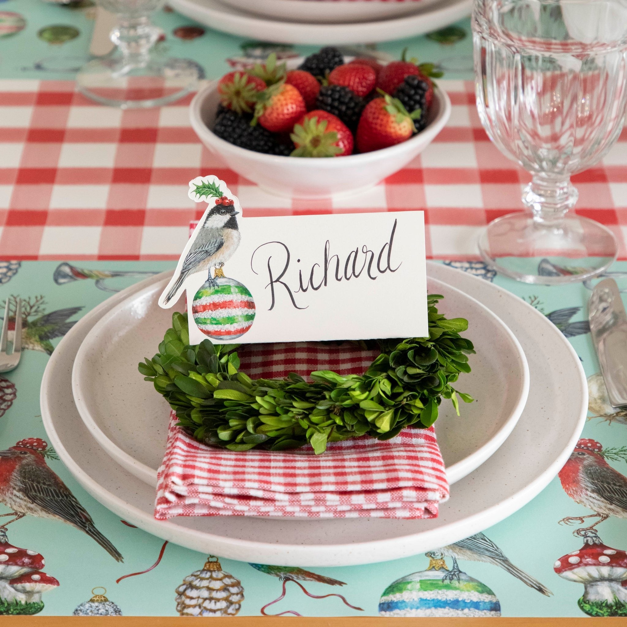 The Christmas Chickadee Place Card with "Richard" written on it, on top of a festive place setting.