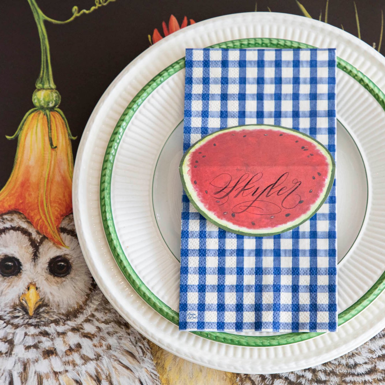 A Navy Painted Guest Napkin centered on the plate of a summertime place setting.