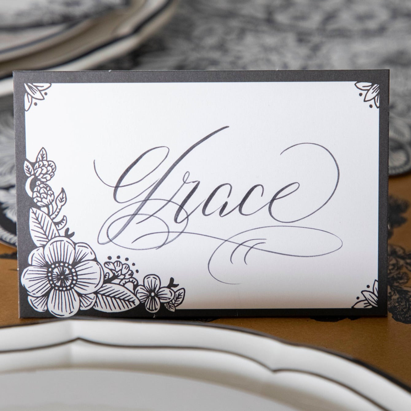 Close-up of an Ebony Harvest Blooms Place Card labeled "Grace" in elegant script.