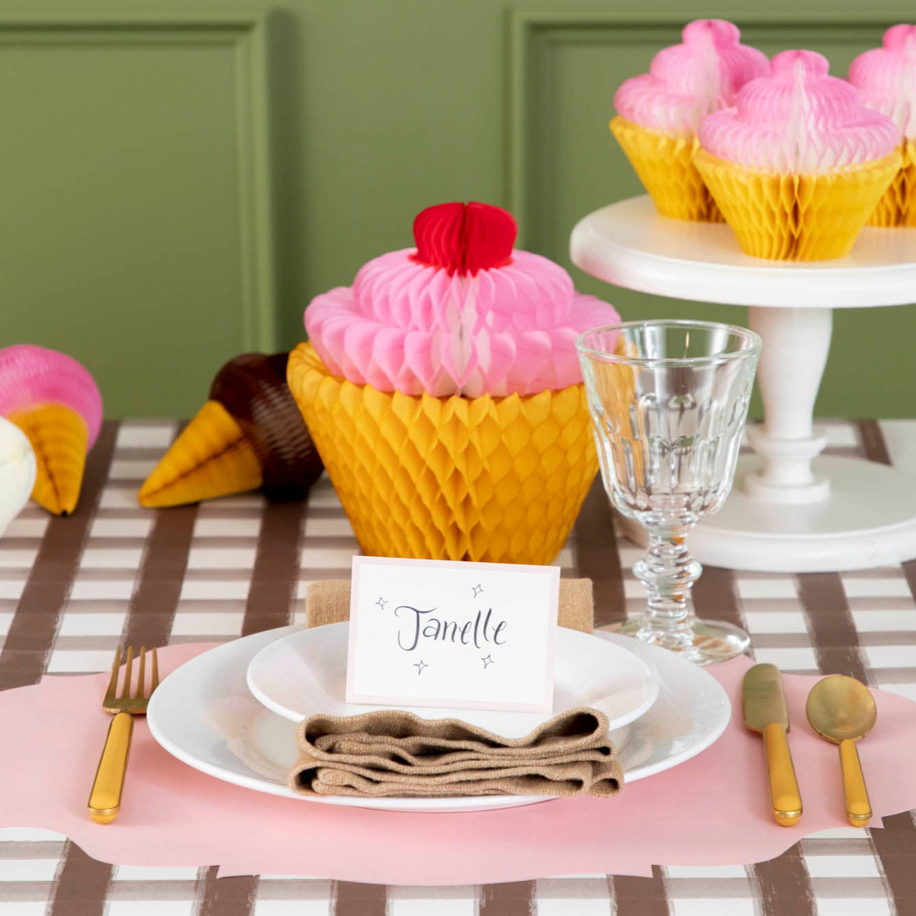 Pink Frame Place Card with "Janelle" written on it, centered on dinner plates, on a sweet treat themed place setting.