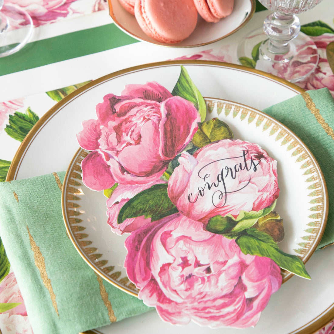 An elegant place setting featuring a Peony Table Accent with &quot;congrats&quot; written on it resting on the plate.