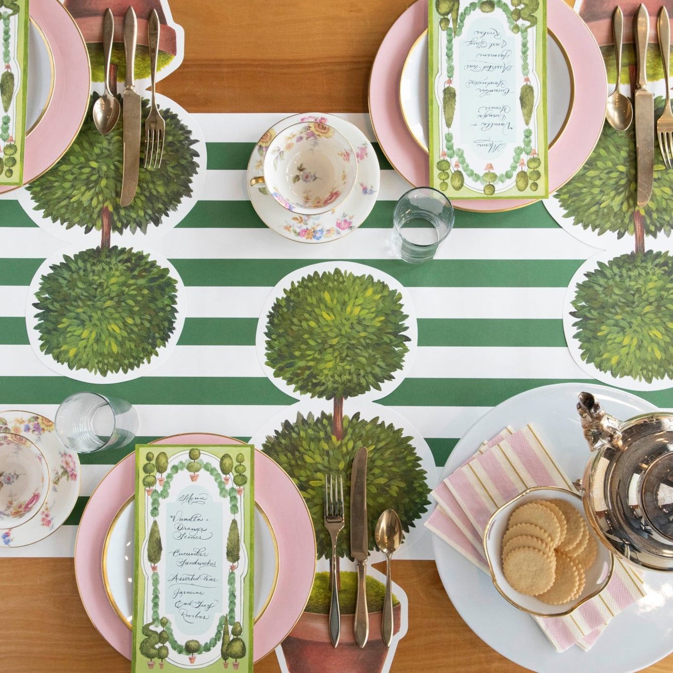 Two Die-cut Topiary Pair Placemats on a table with placemats on a white background. (Brand: Hester &amp; Cook)