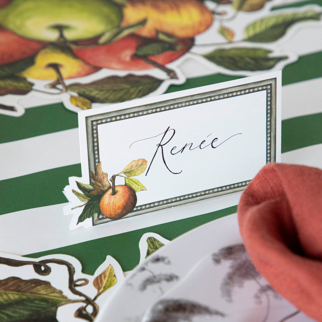 Close-up of a Heirloom Apples Place Card labeled &quot;Renee&quot; on an elegant place setting.