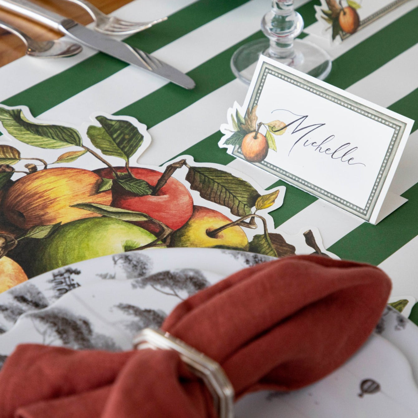 A place setting featuring a Heirloom Apples Place Card labeled &quot;Michelle&quot;.