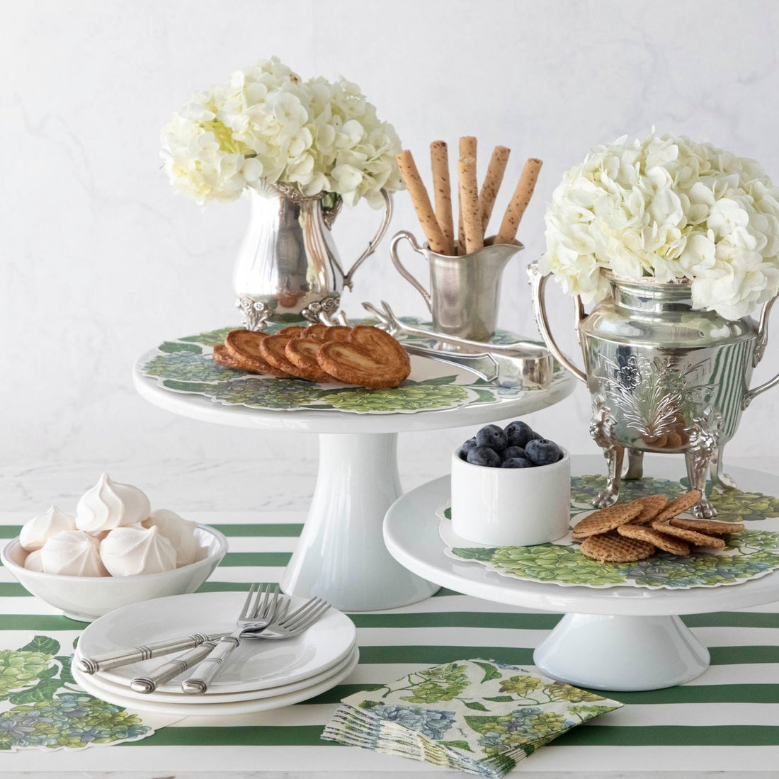 Hydrangea Serving Papers featured in an elegant treat spread with cake stands and vases of flowers.
