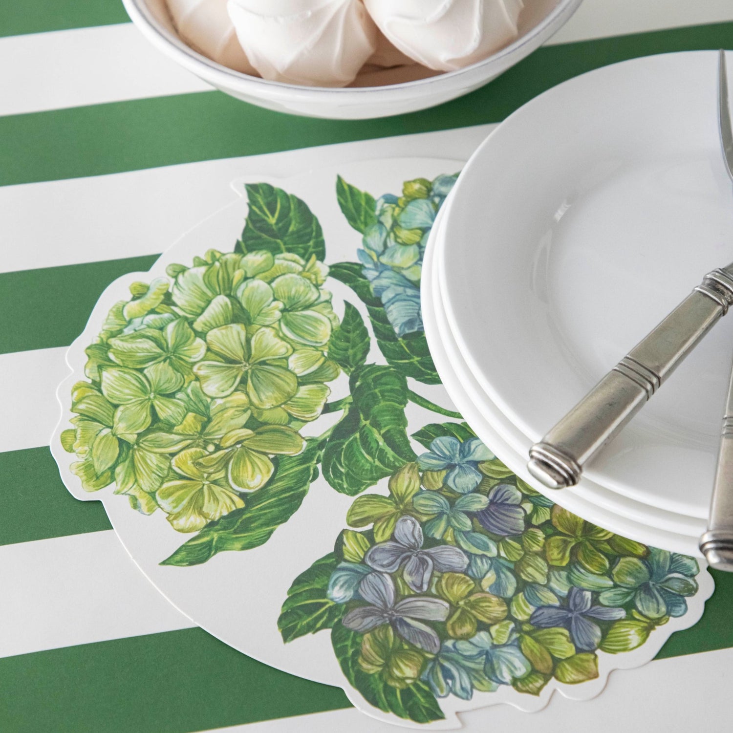 A Hydrangea Serving Paper tucked under the plate of an elegant place setting.