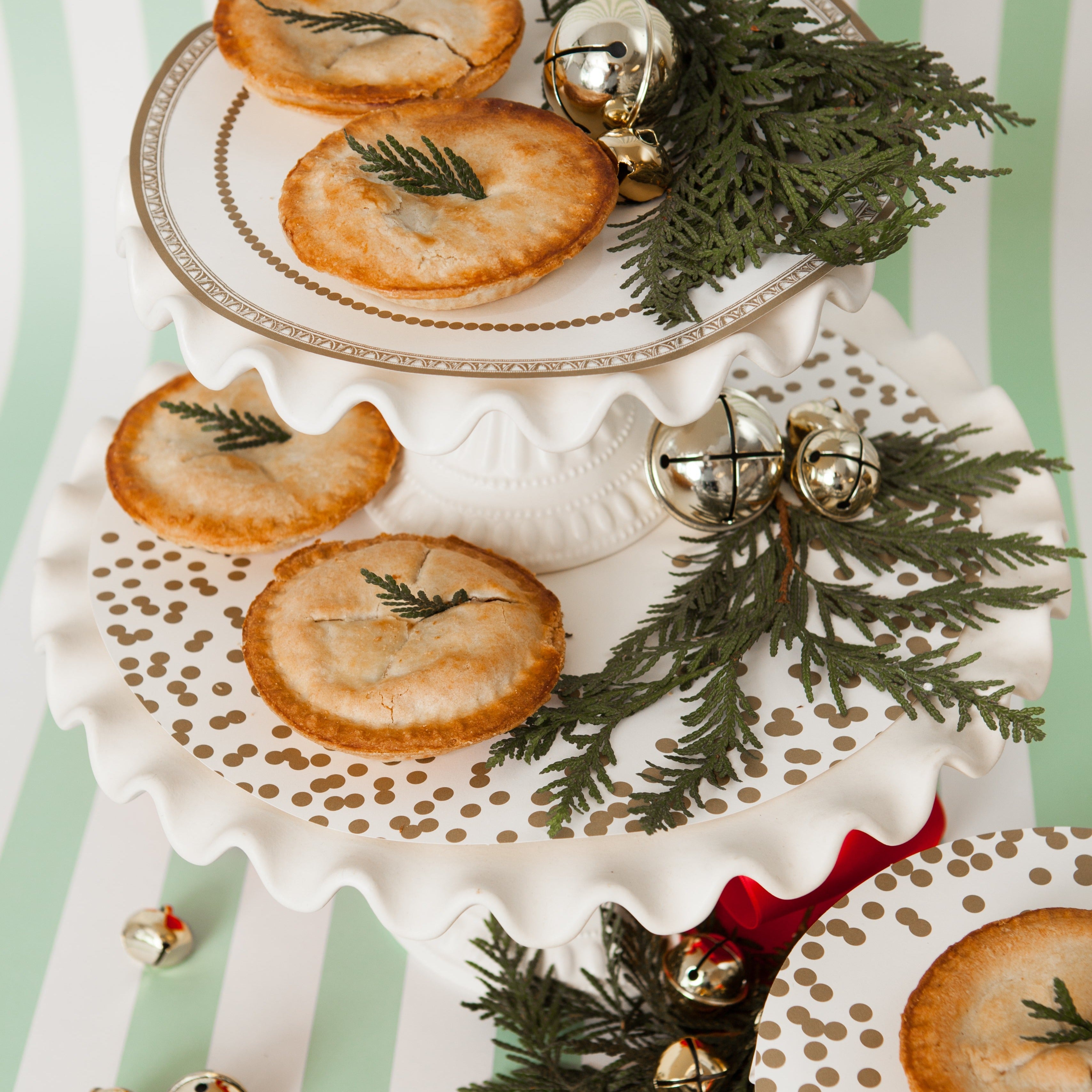 A festive holiday treat table featuring Gold Serving Papers on the cake stands.