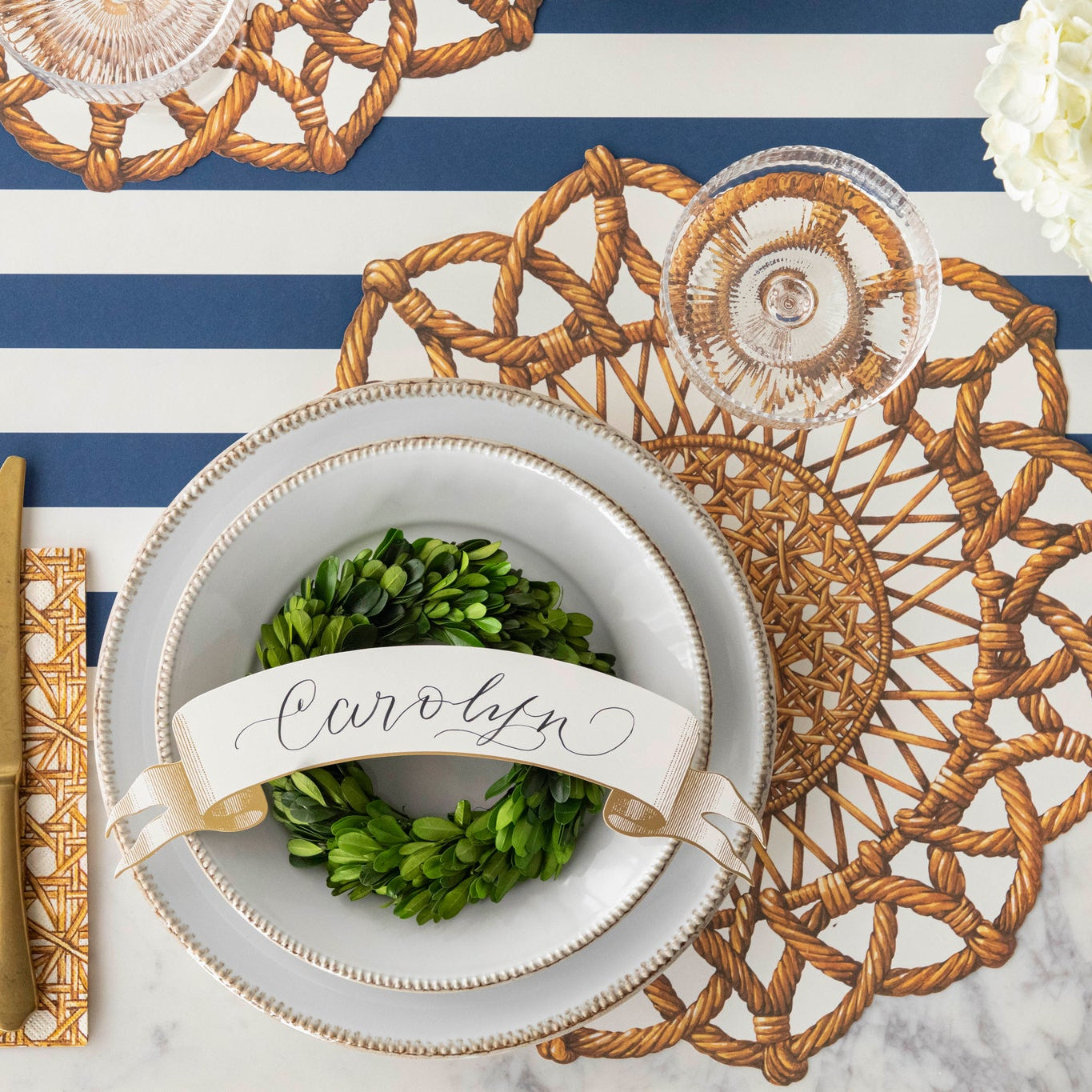Classic Gold Banner Table Accent with "Carolyn" written on it, on the dinner plates of a place setting.