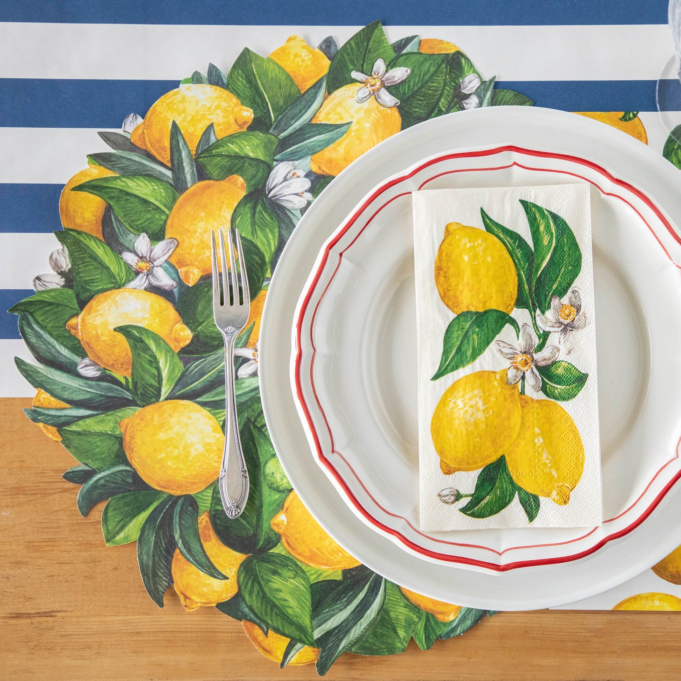 Table setting with a Lemon Wreath Placemat, white plates, Lemons Guest Napkin, and a vintage fork on the Navy Classic Stripe Runner.