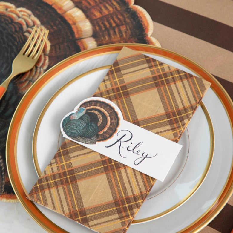 A rustic place setting including a Heritage Turkey Place Card labeled &quot;Riley&quot; laying flat on the plate.