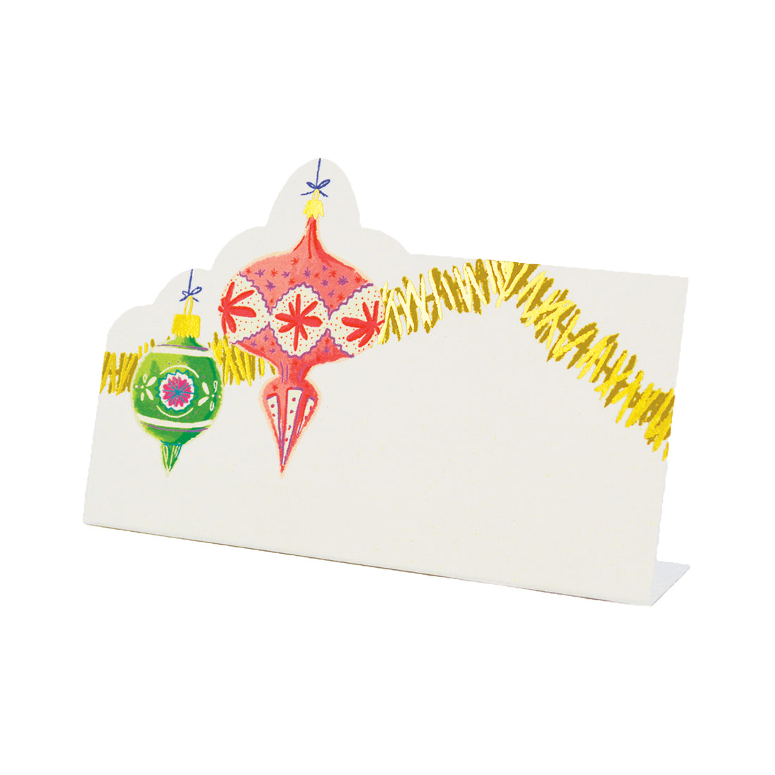 A white, rectangular freestanding place card featuring whimsical artwork of vintage-style Christmas ornaments and gold tinsel adorning the top and right edges of the card.