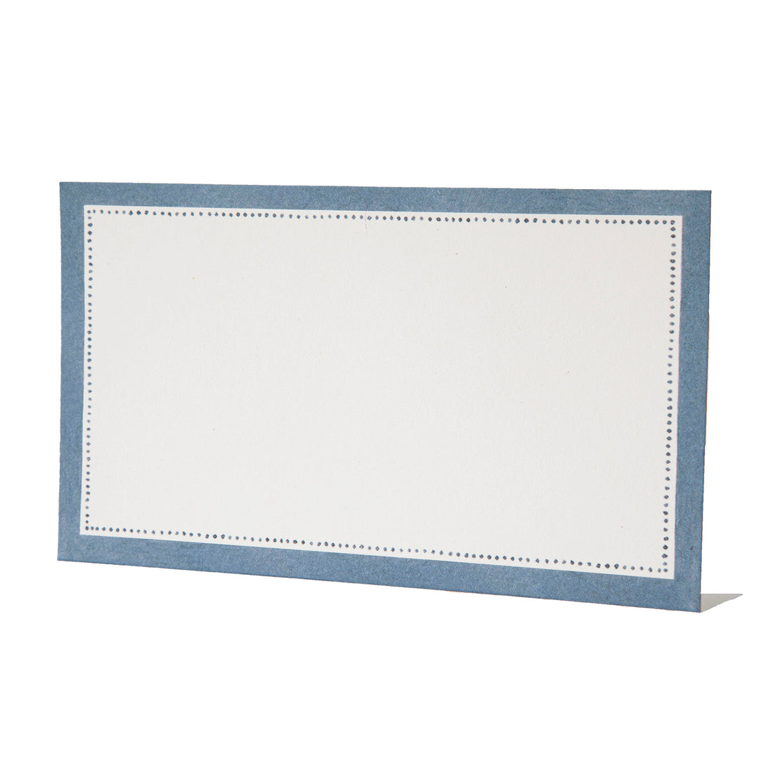 A free-standing, rectangular white table card with a medium blue frame around the edges, accented with a row on small blue dots just inside the frame.