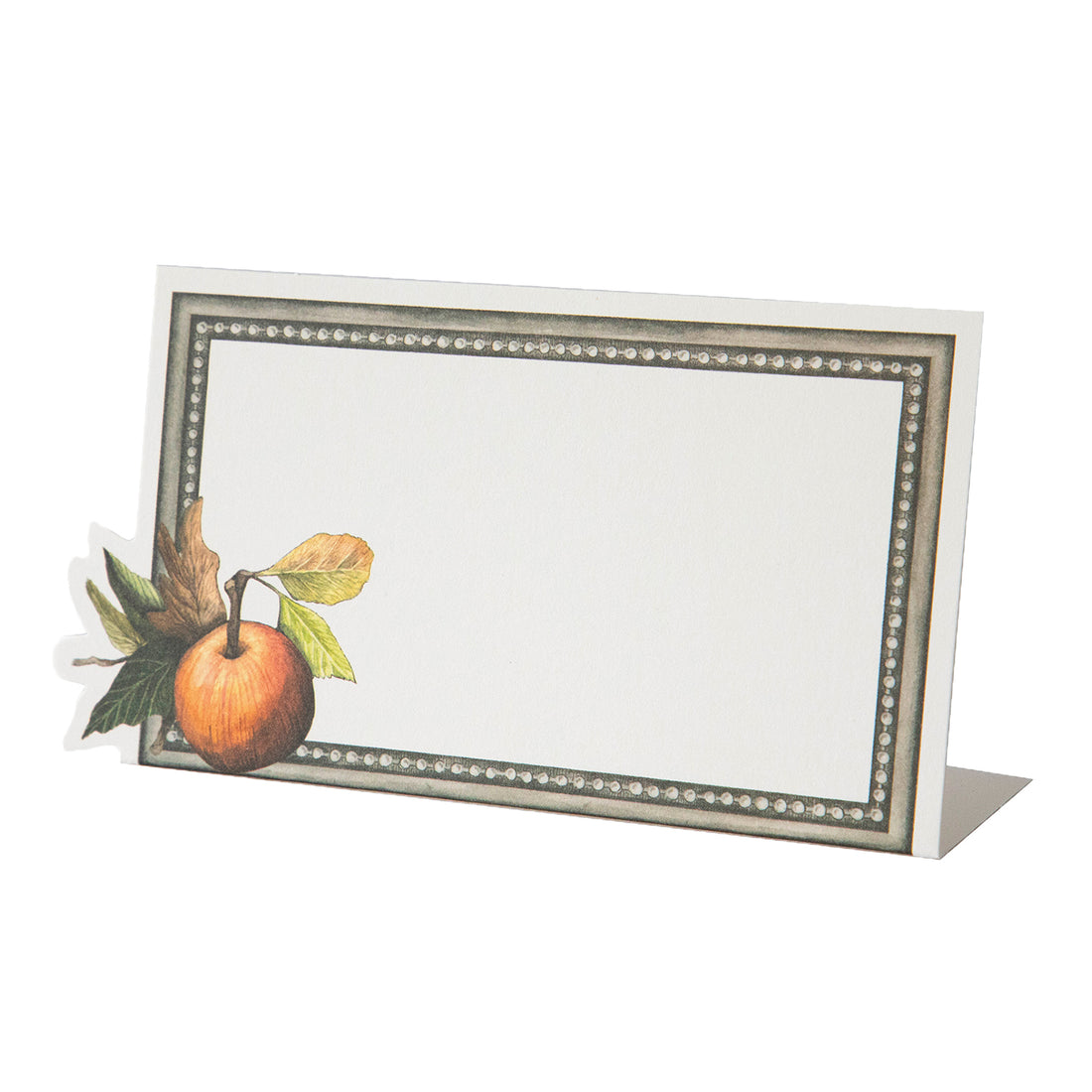 A white, rectangular freestanding place card featuring an ornate gray frame and a vibrant orange apple with leaved adorning the lower left corner.