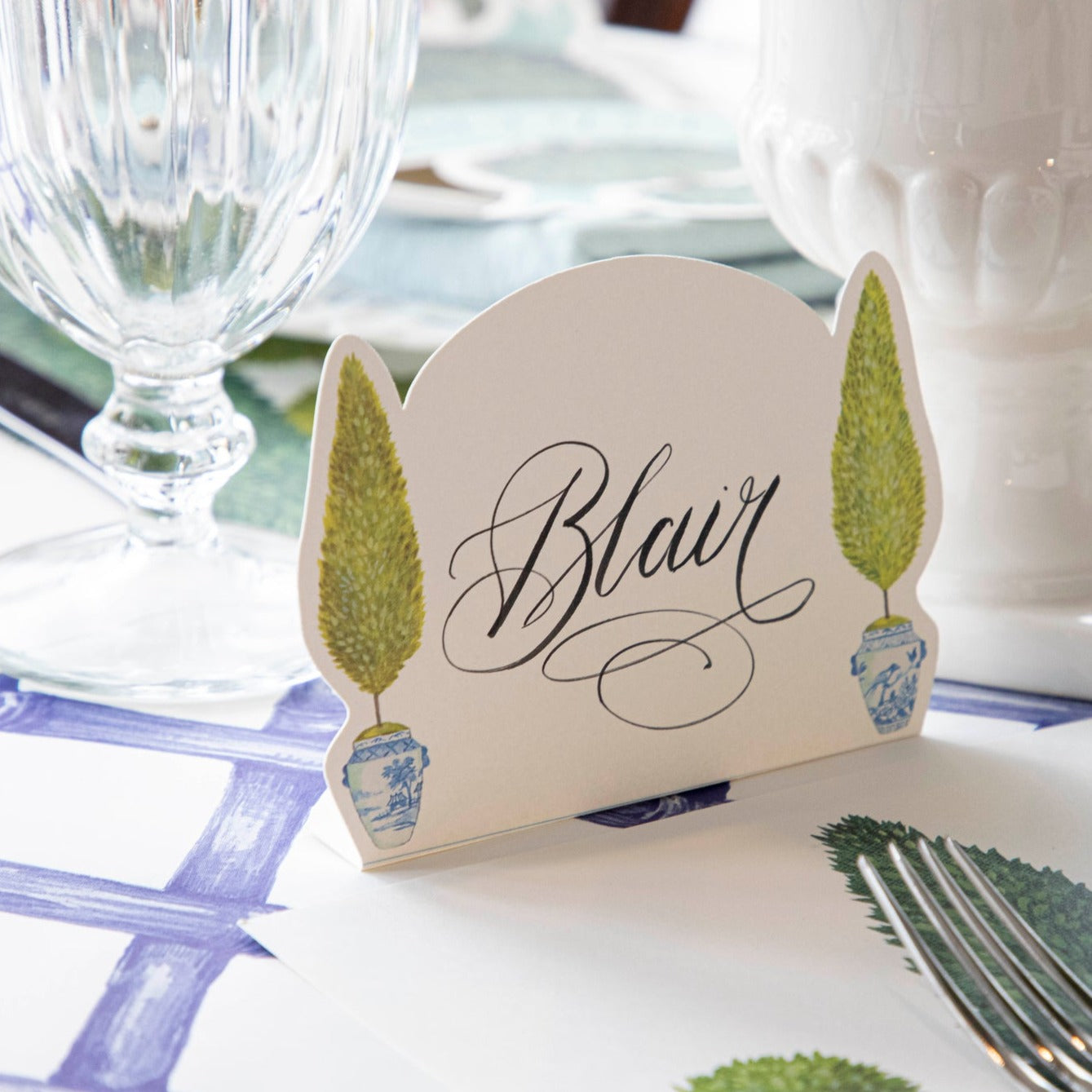 Close-up of a Topiary Place Card labeled "Blair" standing on an elegant table setting.