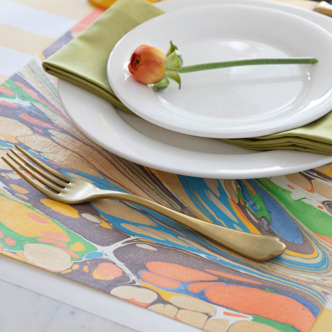 Close-up of the Multi Color Fantasy Marbled Placemat under a place setting. 