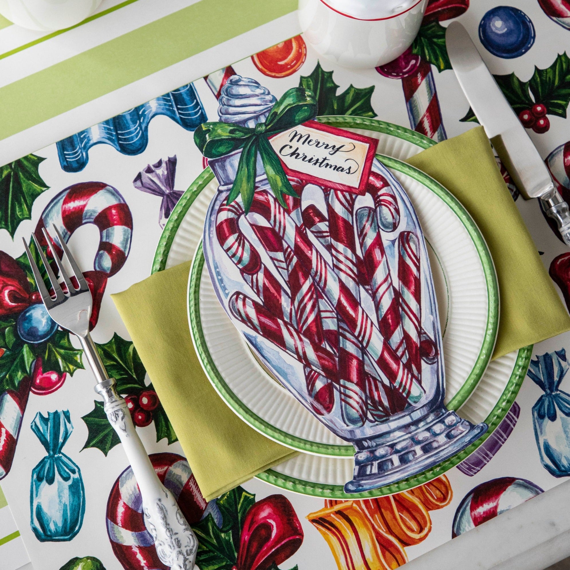 Close-up of the Candy Cane Shoppe Placemat under a festive Christmas-themed place setting.