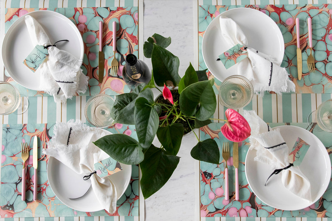 The Seafoam &amp; Red Stone Marbled Placemat under an elegant table setting for four, from above.