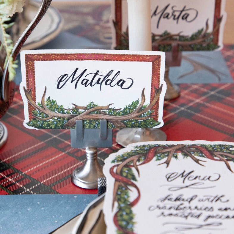 Close-up of an Antler Frame Place Card for "Matilda" in a place card stand, as part of a festive winter tablescape.
