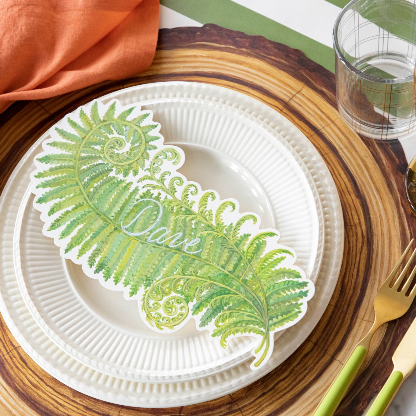 Fern Table Accent with "Dave" written on it, resting on dinner plates, on a nature themed place setting.