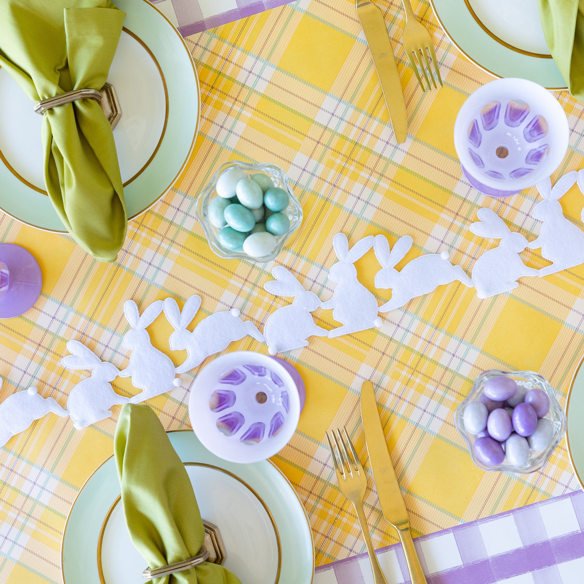 Rabbit Garland Ribbon with white appliqué rabbits made of felt running down a table with a yellow plaid runner and purple glasses on it.