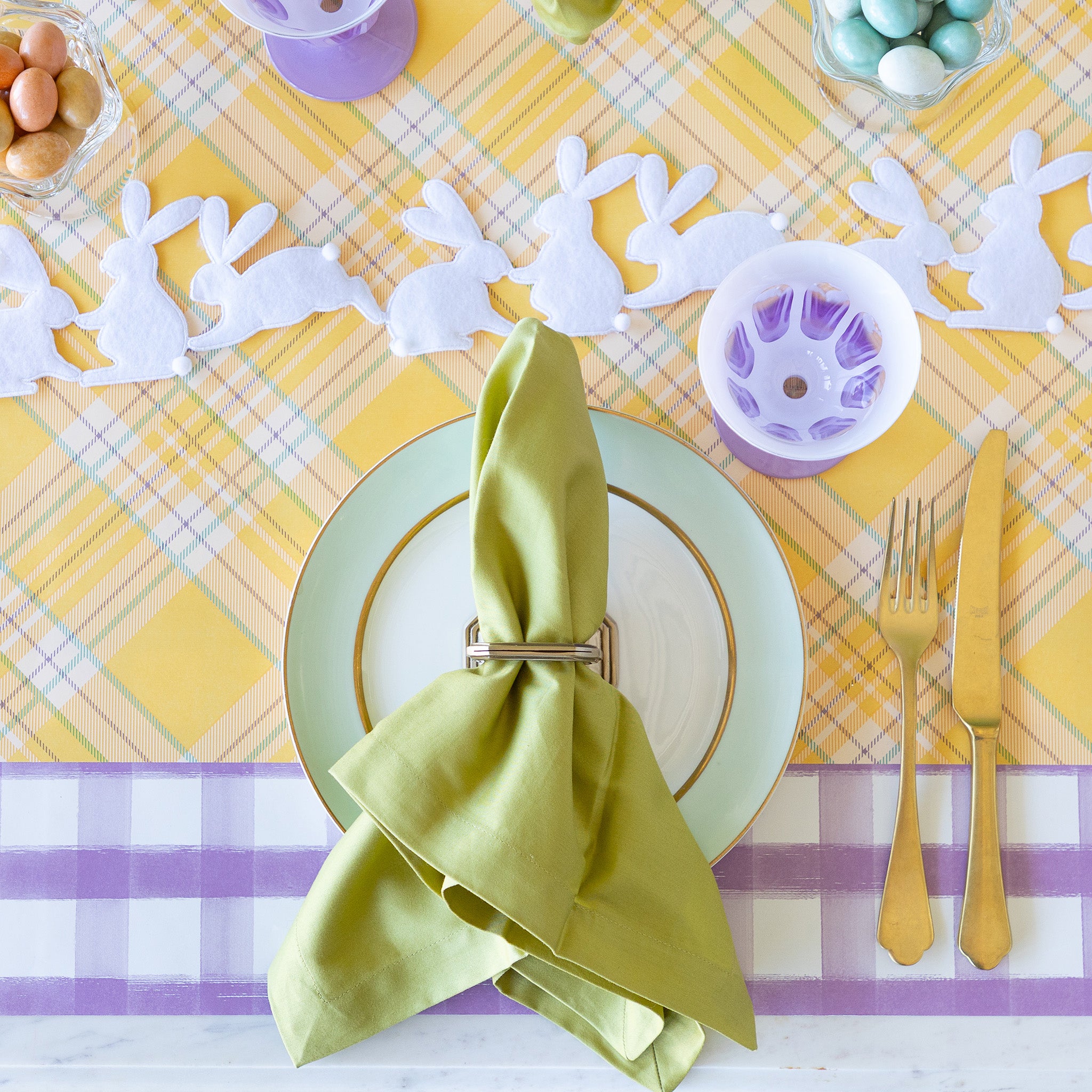 Rabbit Garland Ribbon with white appliqué rabbits made of felt running down a table with a yellow plaid runner and purple glasses on it.