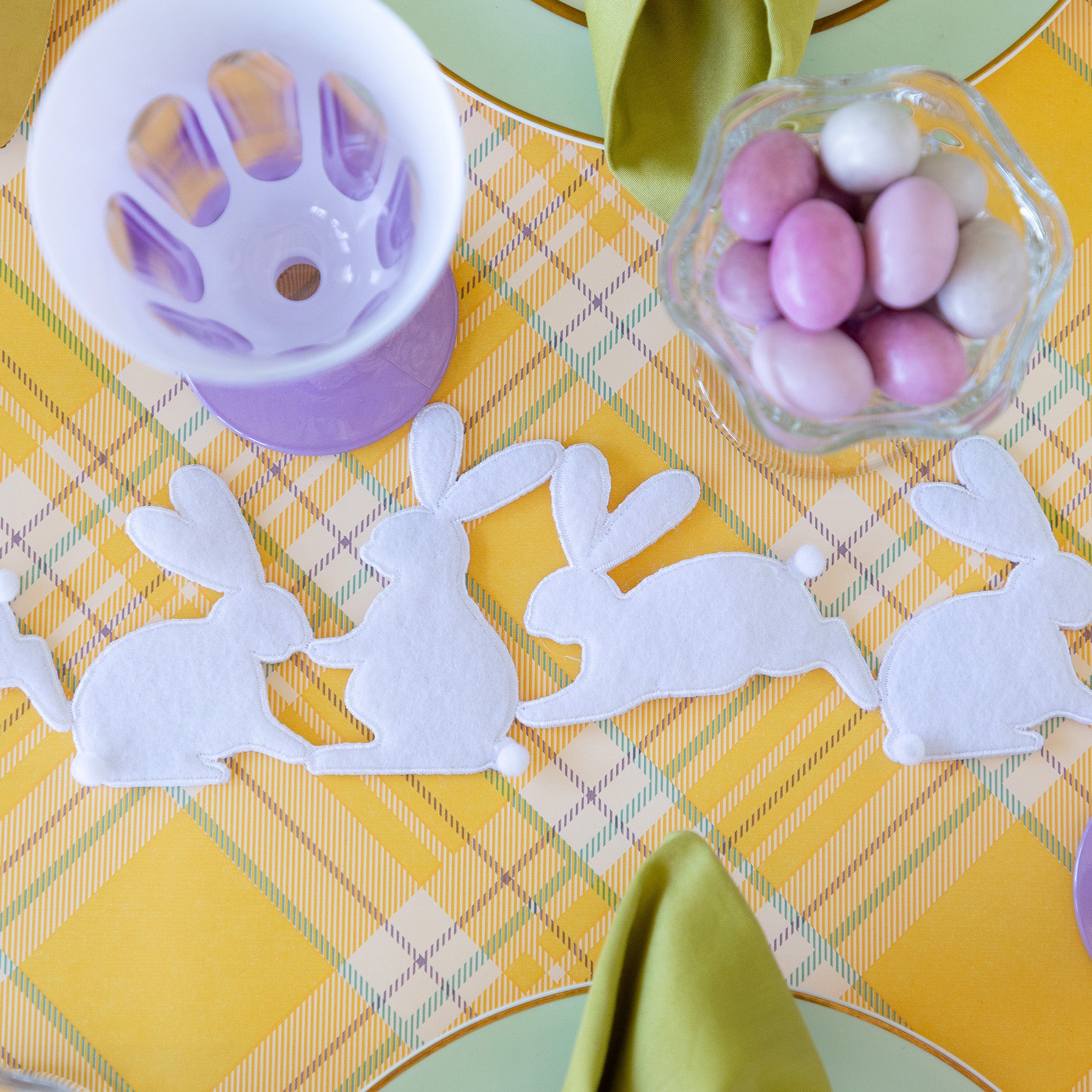 Rabbit Garland Ribbon with white appliqué rabbits made of felt running down a table with a yellow plaid runner and purple glasses on it.