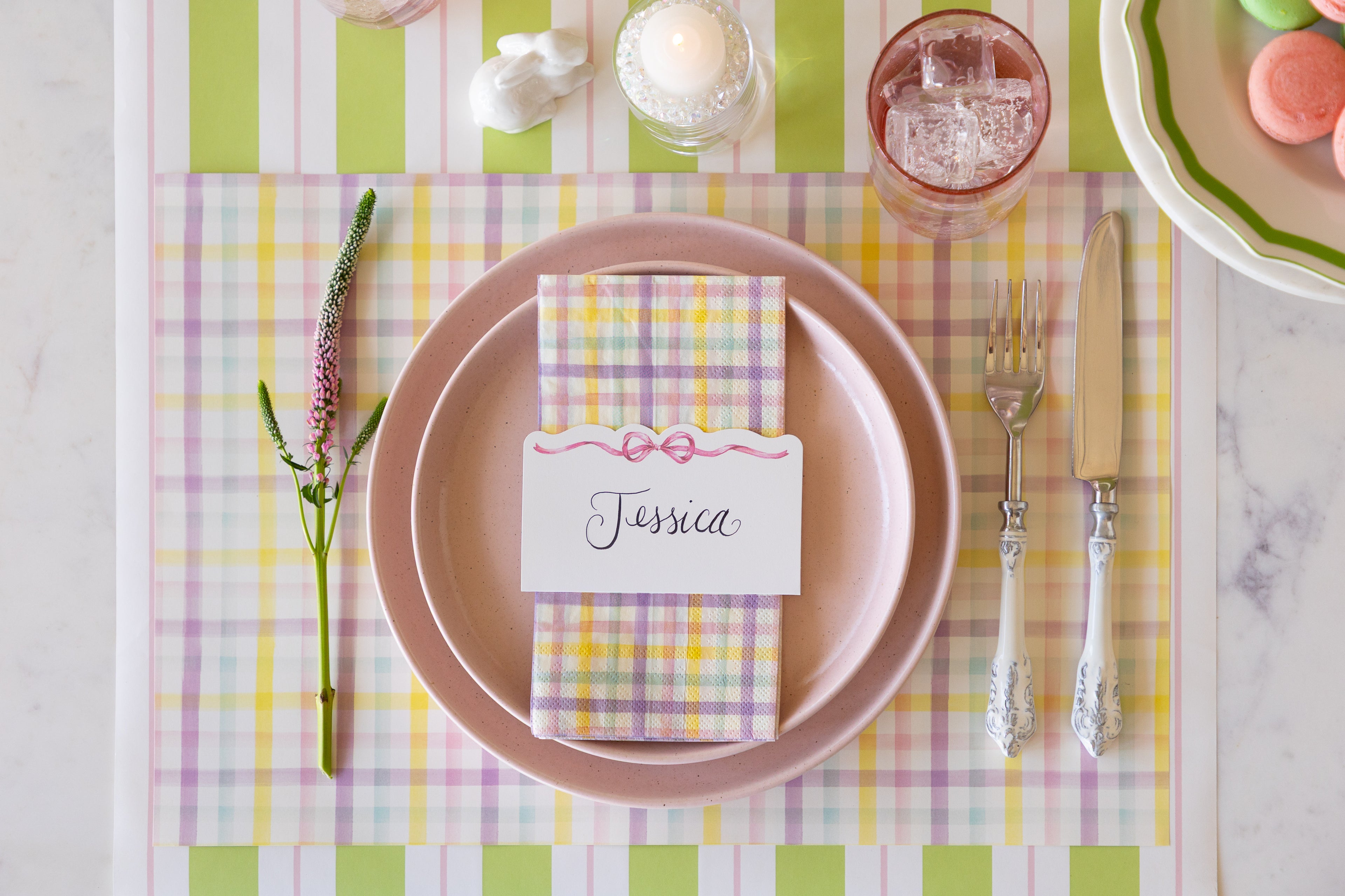 Spring Plaid Placemat with pink plates, Spring Plaid Guest Napkin and Pink Bow Place Card on top, on the Green & Pink Awning Stripe Runner.