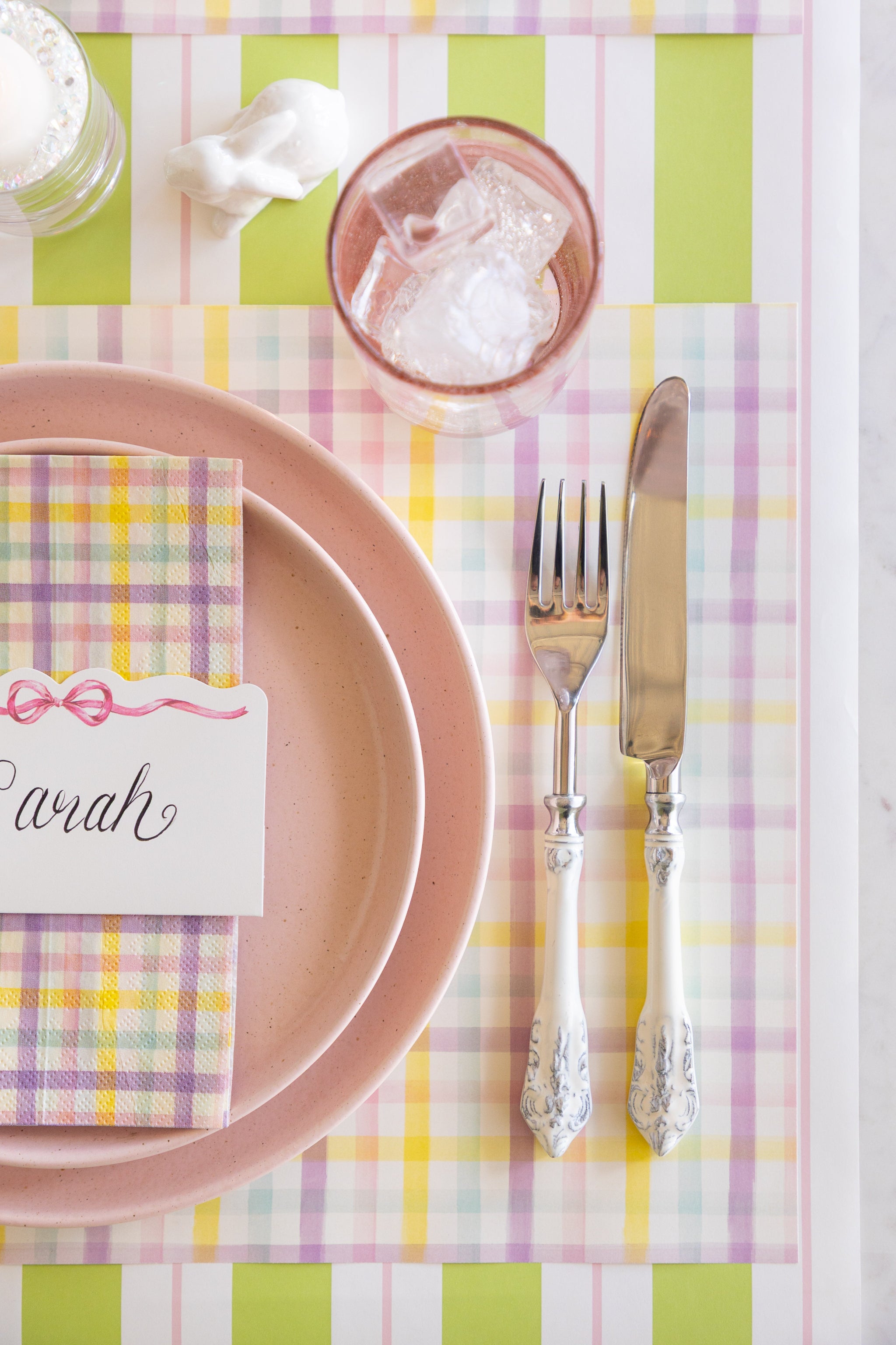 Spring Plaid Placemat with pink plates, Spring Plaid Guest Napkin and Pink Bow Place Card on top, on the Green & Pink Awning Stripe Runner.