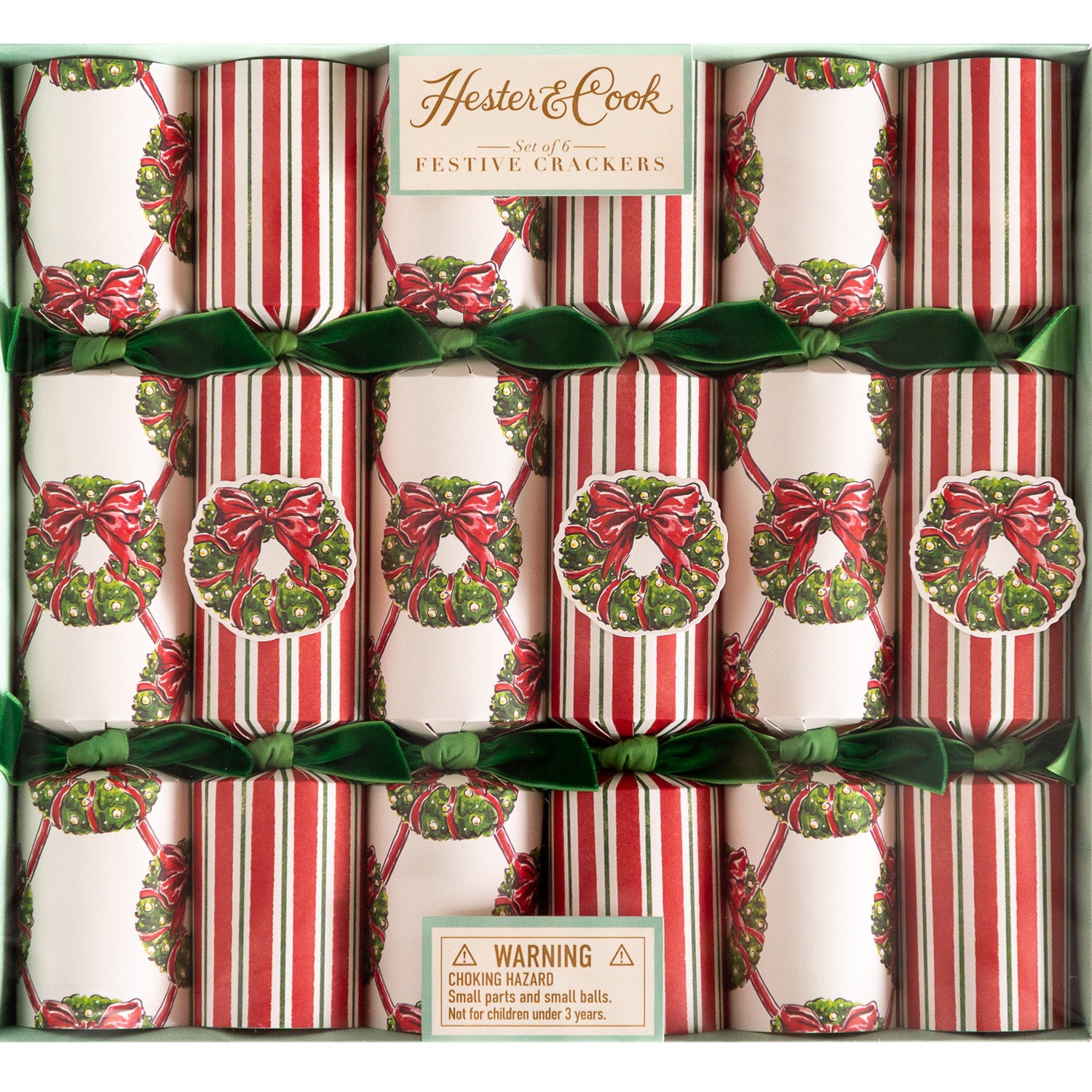 A box of Hester & Cook Holiday Wreath Crackers; some decorated with a wreath lattice pattern and others a red and green stripe pattern––all tied with green velvet ribbons.