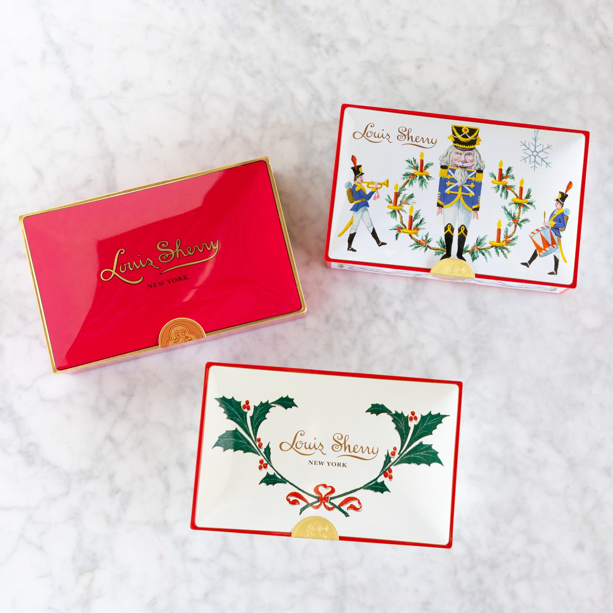 Louis Sherry gift box with decorative cards on a textured white surface.