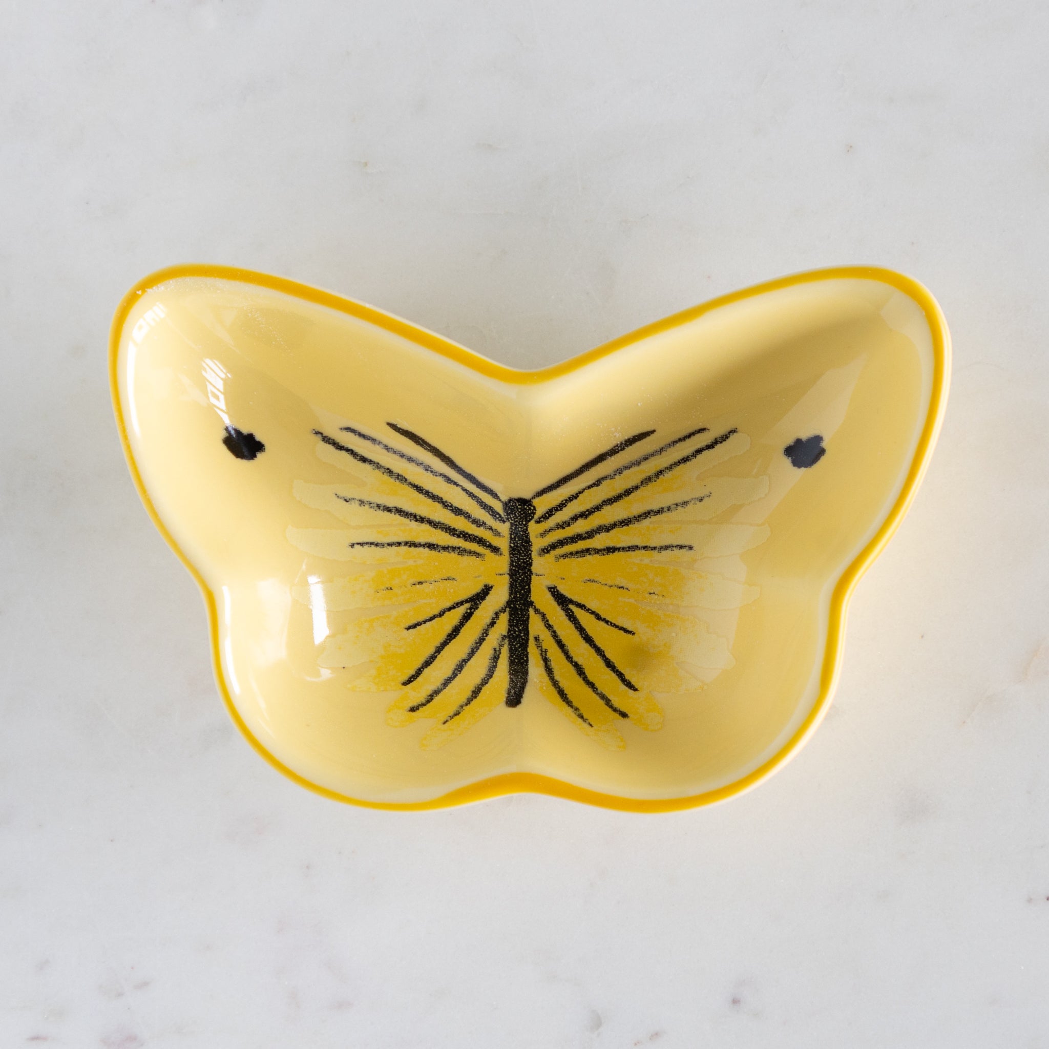 Yellow butterfly-shaped dish on a light gray background.