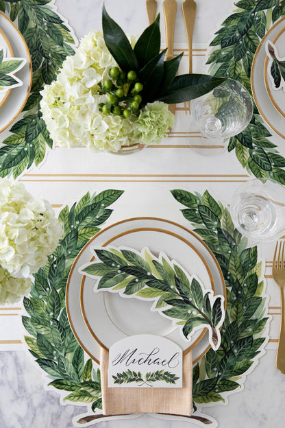 The Die-cut Green Laurel Wreath Placemat under an elegant table setting, from above.