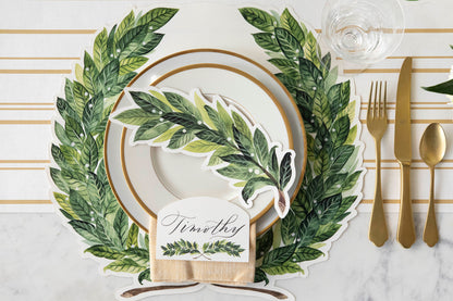 An elegant place setting featuring a Laurel Place Card labeled &quot;Timothy&quot; laying flat on the plate, from above.