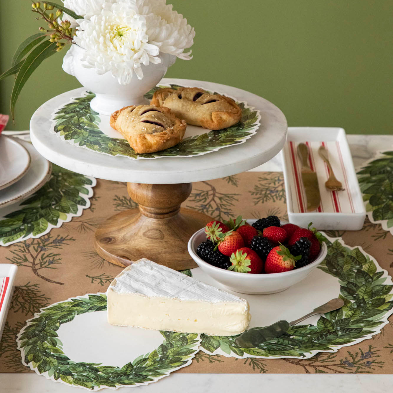Laurel Serving Papers styled on a winter themed table setting adorned with pastries, berries and block of cheese.