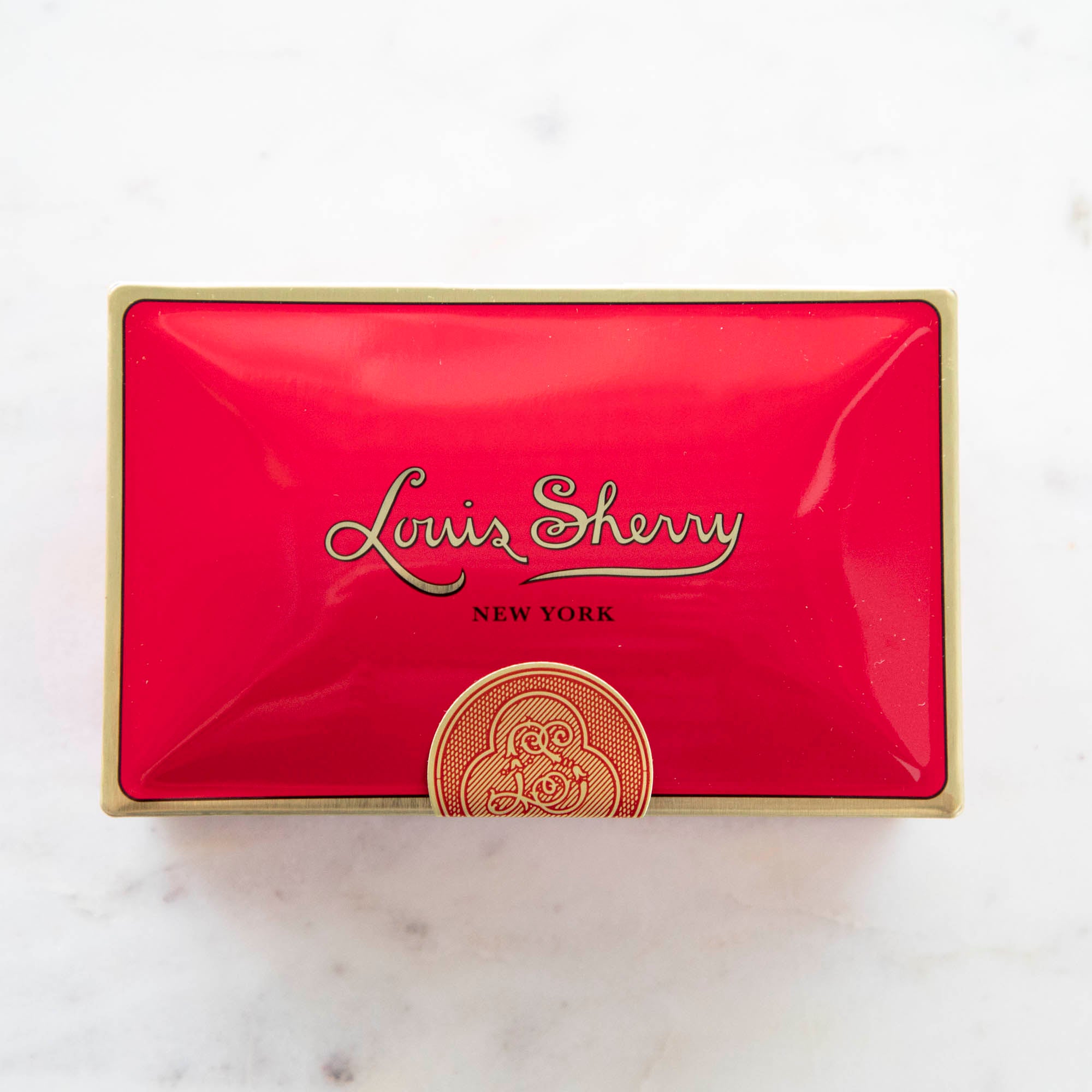 Tin Louis Sherry chocolate box in bright red with gold details.