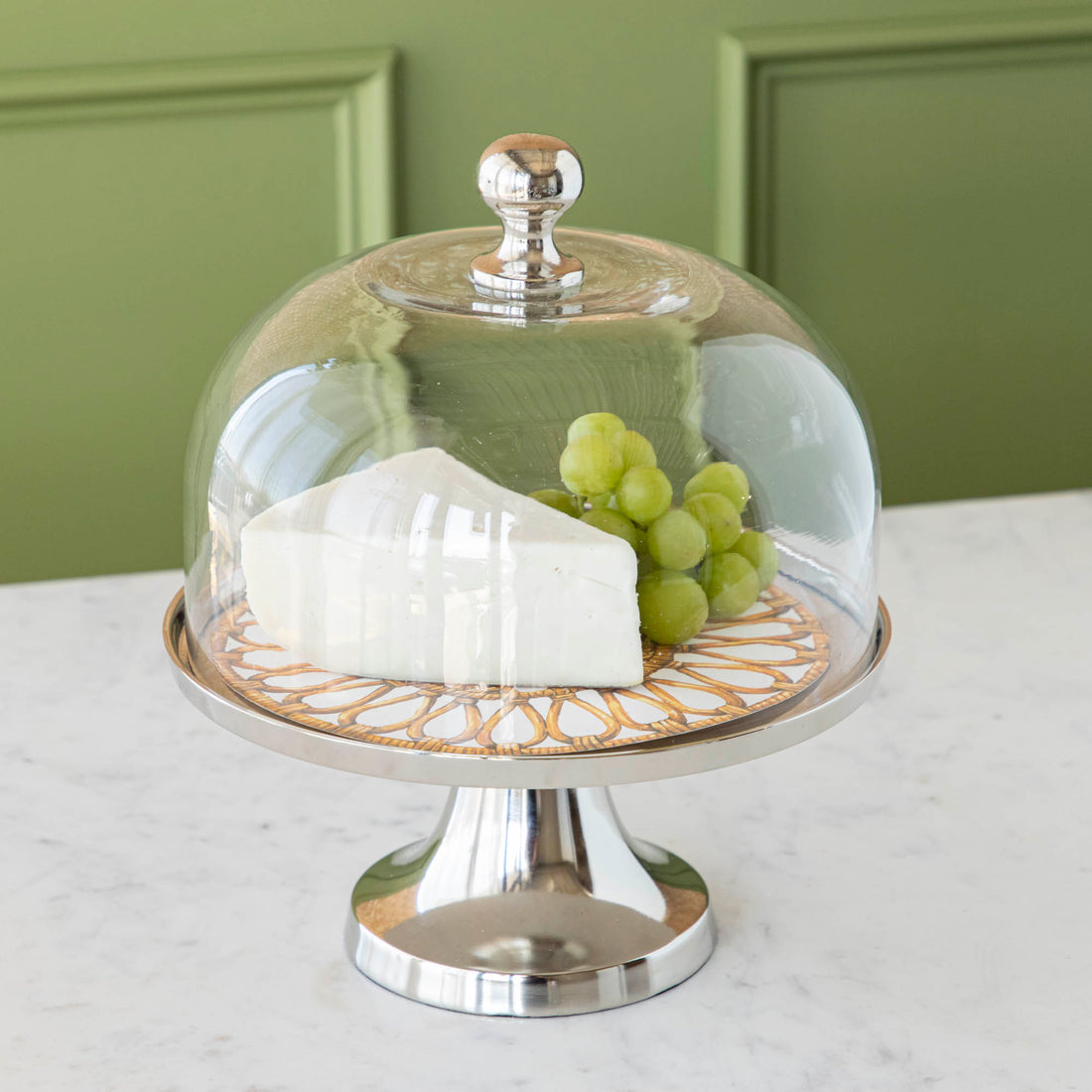 Aluminum serving stand with glass dome on white background
