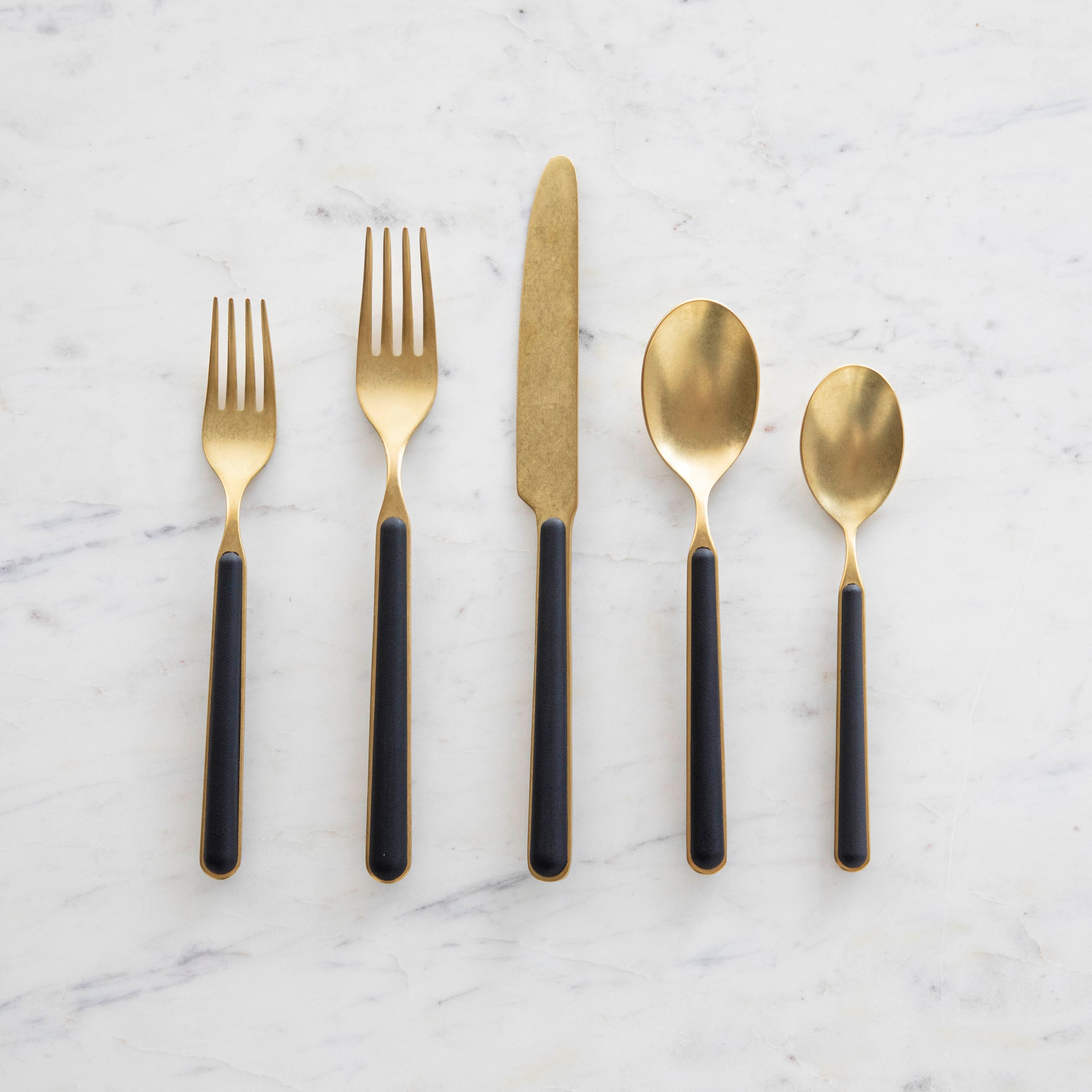 Fantasia Black 5-Piece Place Setting by Mepra neatly arranged on a marble surface.
