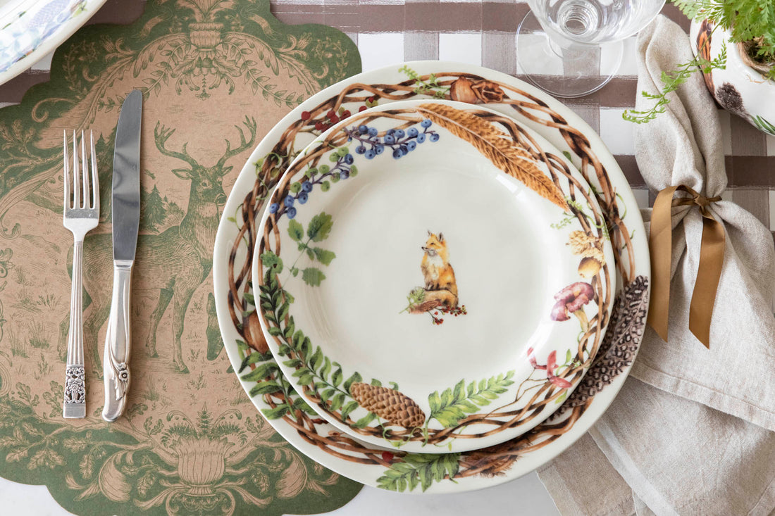 A table setting with Forest Walk Dinnerware from the Juliska Collection, silverware, and utensils.