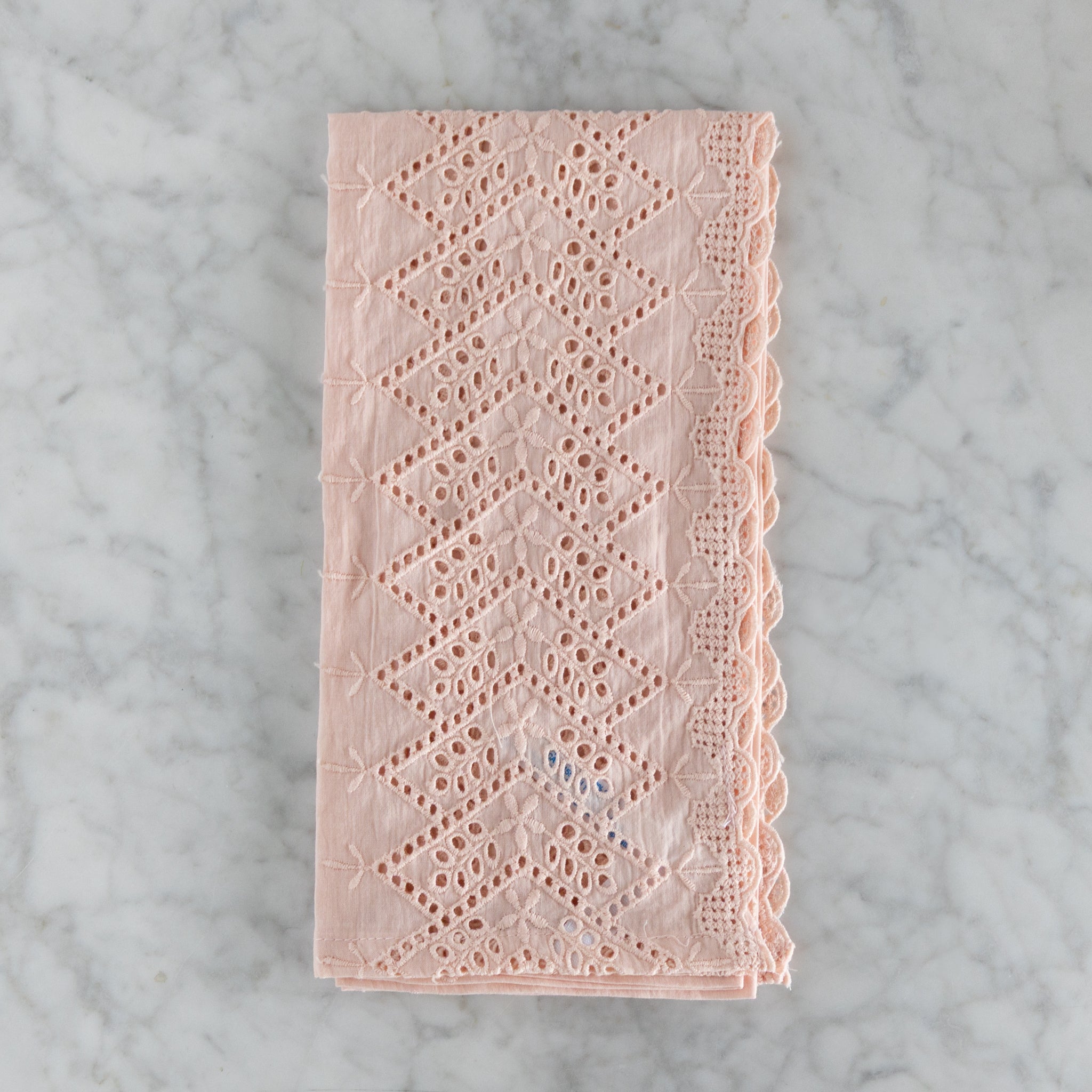 Pink lace napkin on a marble surface.