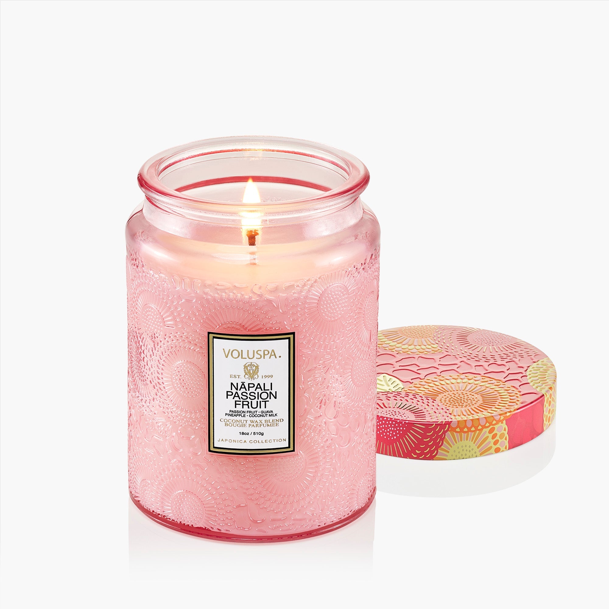 Pink candle in a glass jar with a decorative lid on a white background
