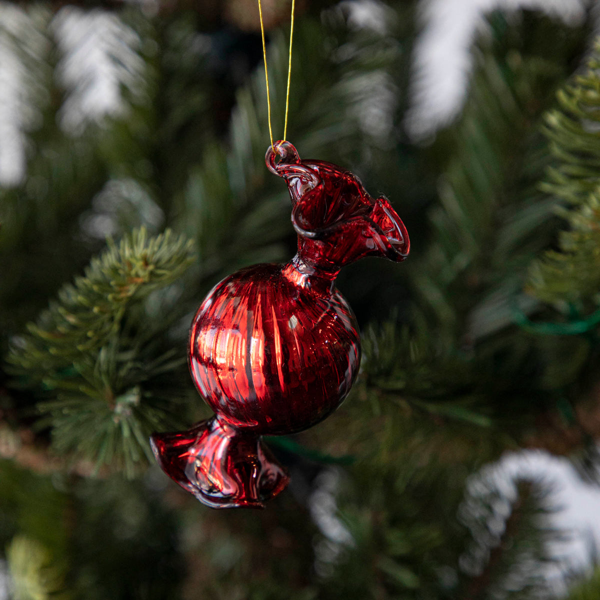 Close up of the Red Round Candy Shaped Ornament hanging in a tree