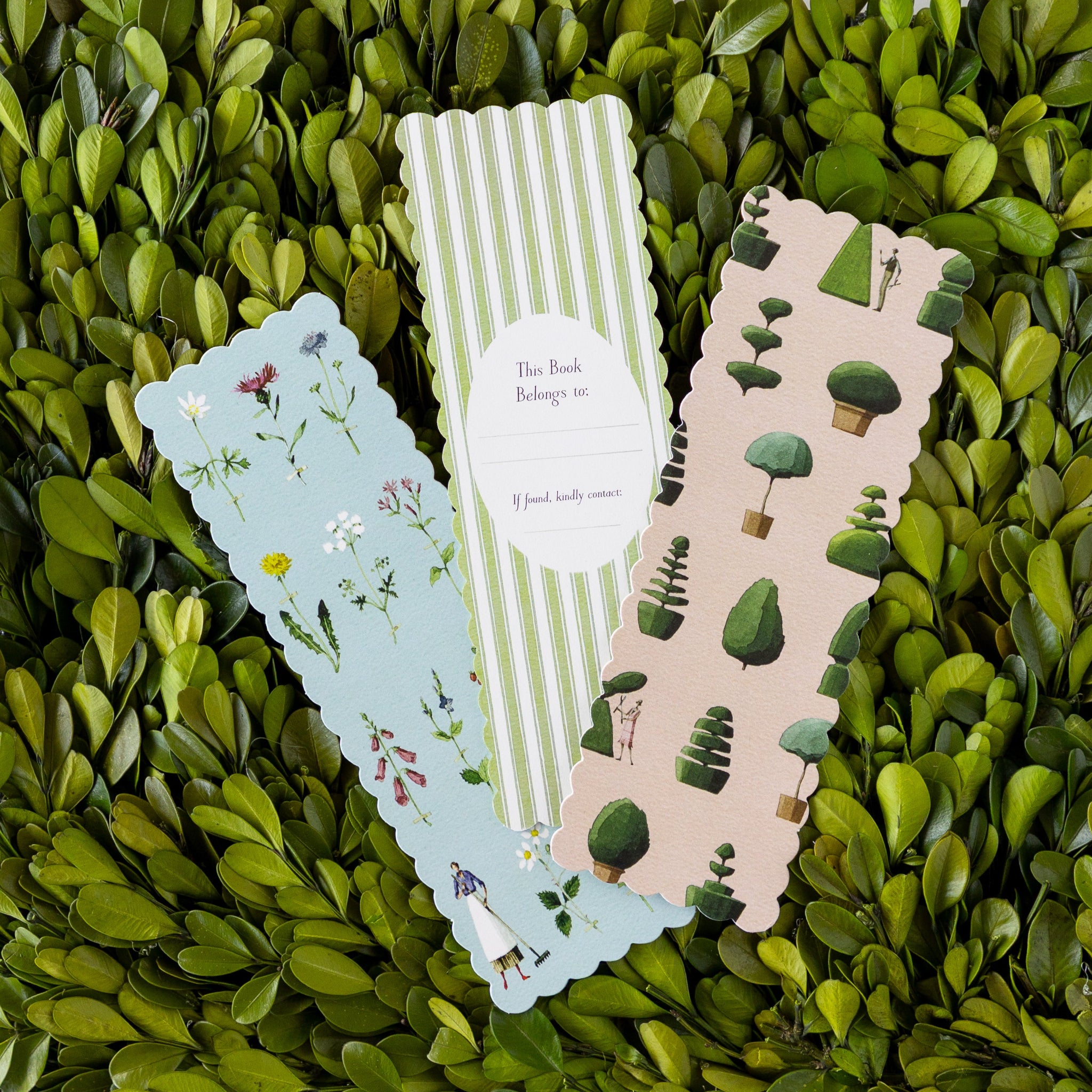 Three decorative bookmarks on a green leafy background.