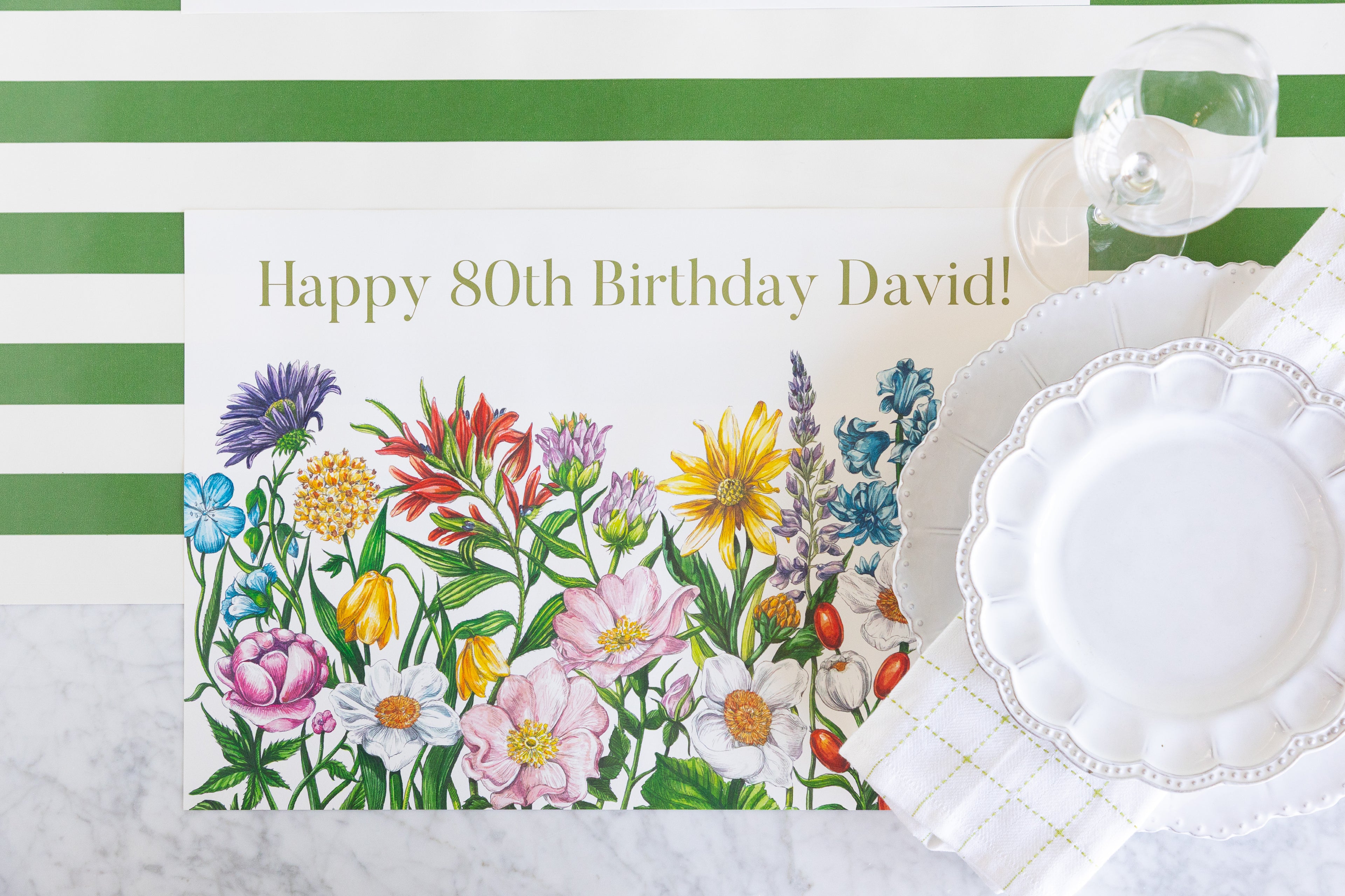 A rectangular birthday placemat with a colorful wildflower illustration and the text &