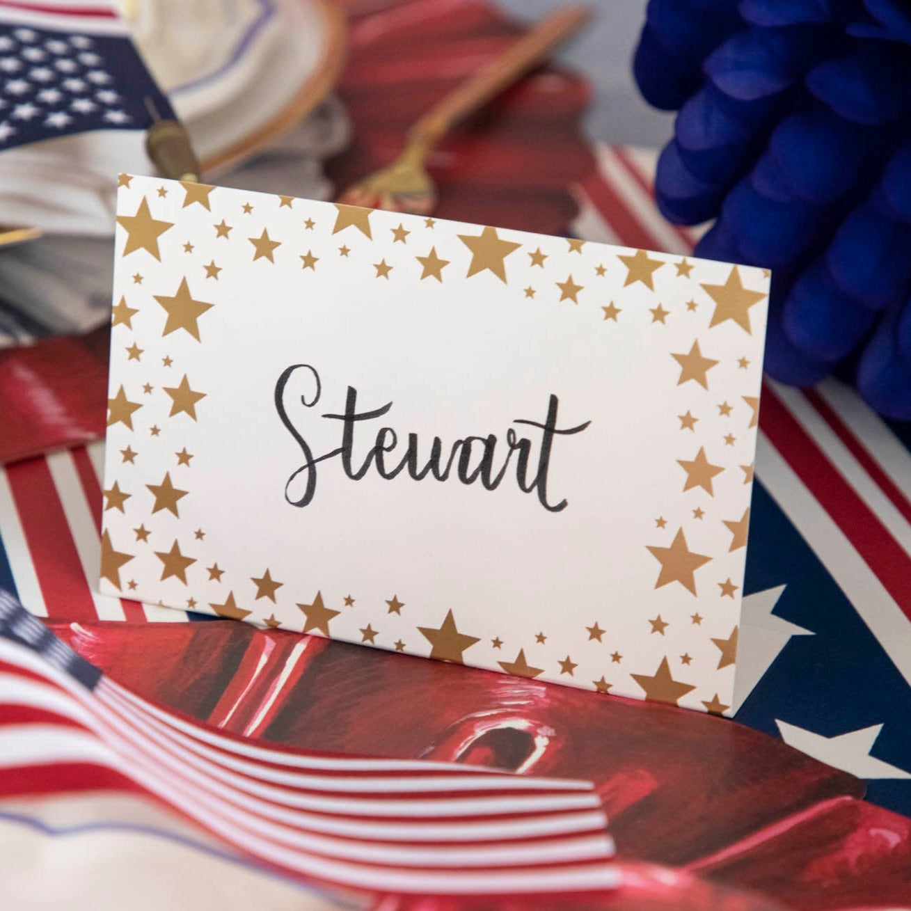 Close-up of a Shining Star Place Card labeled &quot;Steward&quot; on a patriotic tablescape.