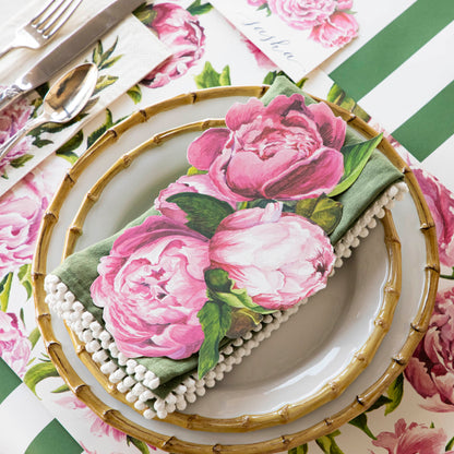 An elegant place setting featuring a Peony Table Accent resting on the plate.