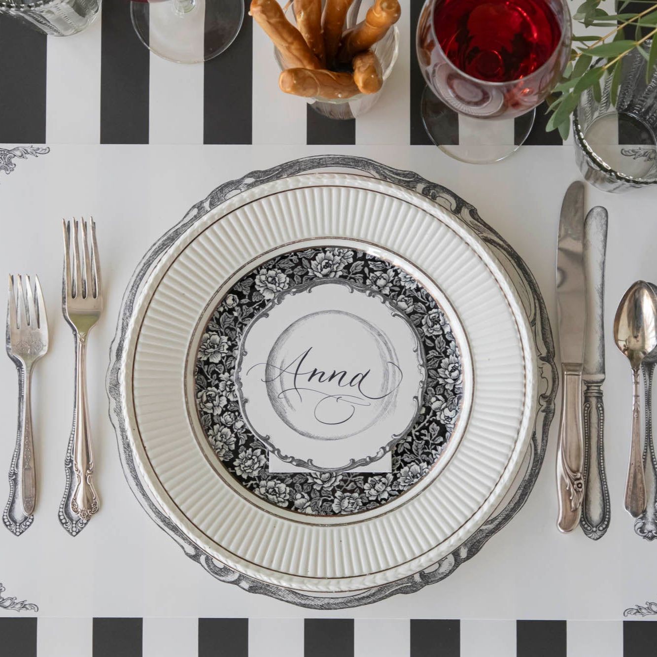 Vintage Plate Place Card with "Anna" written on it, laying flat on dinner plates, on an elegant place setting for one.