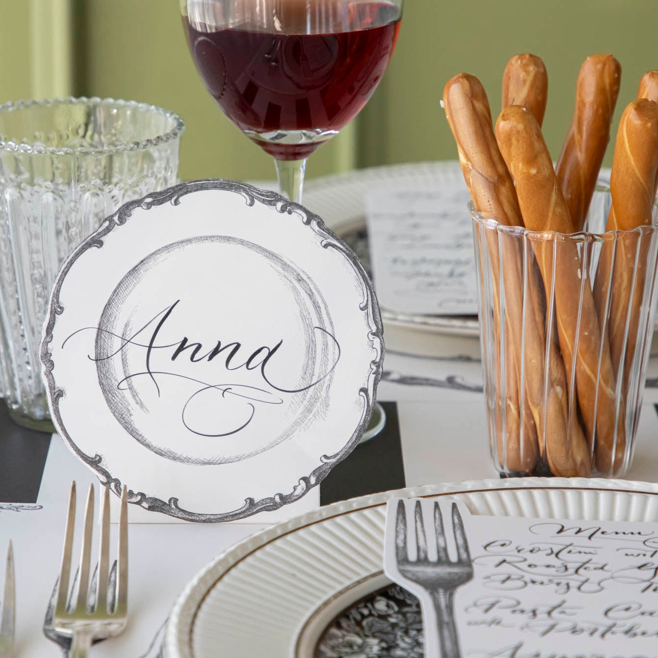 Vintage Plate Place Card with "Anna" written on it, behind a place setting for one.
