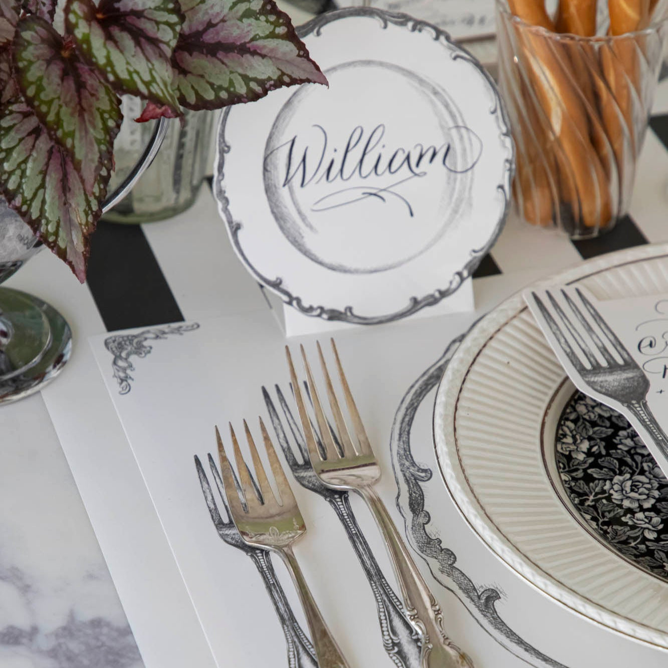 Vintage Plate Place Card with "William" written on it, behind a place setting for one.